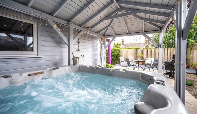 The Retreat Cabin with covered hot tub, sauna & cinema room.
